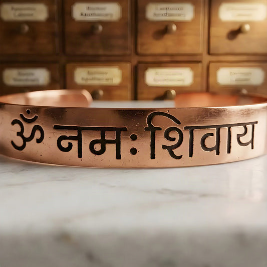 Makroaufnahme der Om-Namah-Shivaya-Gravur auf dem Kupferarmreif