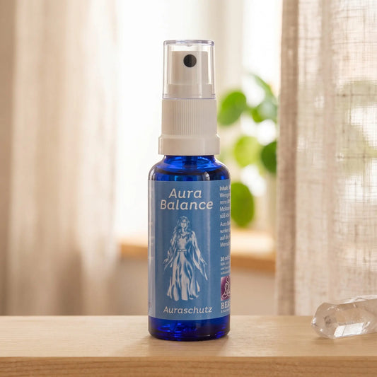 Energiespray Auraschutz (Aura Balance): Sprühflasche auf einem hellen Holzregal am Fenster mit Leinenvorhang, daneben ein Bergkristall