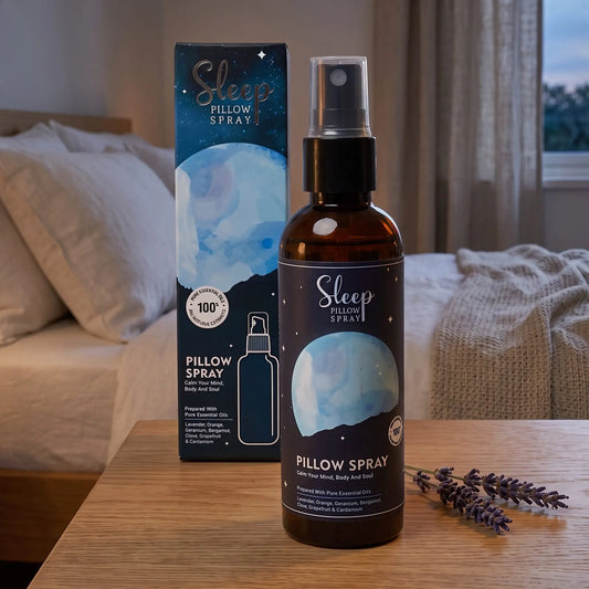 Kissenspray Sleep mit Schachtel auf dem Nachttisch im Schlafzimmer am Abend, dahinter Bett mit Leinenkissen