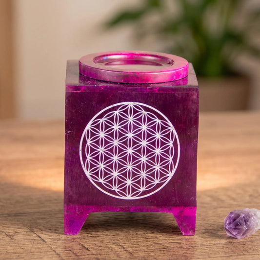 Aromalampe Blume des Lebens: auf einem Holz-Sideboard im Wohnzimmer am Abend, daneben ein Amethyst