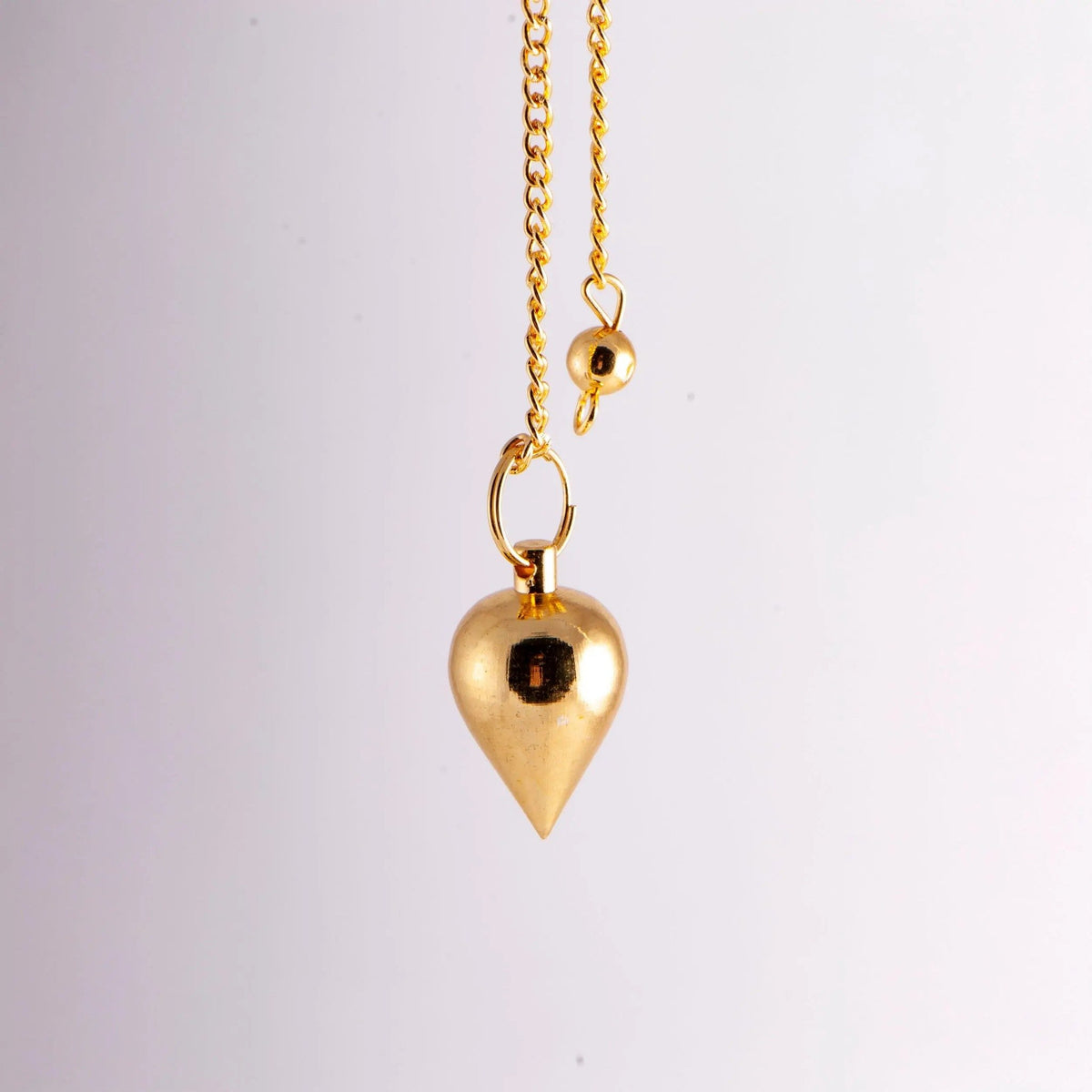 Klassisches Tropfenpendel aus vergoldetem Messing, 2,4 cm, mit Kette: hängend an der Kette vor hellem Grund