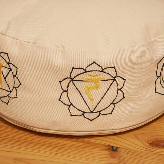 7-Chakra Meditationskissen, naturweiß, Ø 30 cm, Höhe 15 cm, Buchweizenfüllung: Nahaufnahme der gestickten Chakra-Symbole am Rand des Baumwollbezugs – Spirit of Gaia