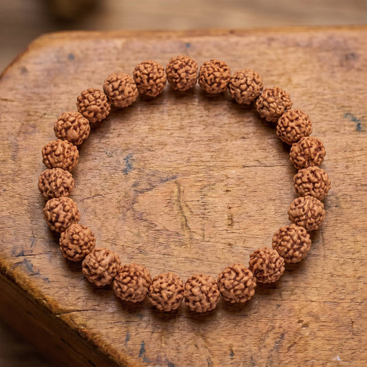 Draufsicht auf das Rudraksha Armband auf altem Holz: zerfurchte Rudraksha-Samen in einer Reihe