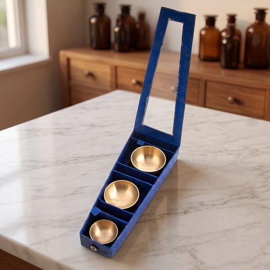 Geöffnete blaue Geschenkbox mit drei Fächern, in denen drei goldfarbene Klangschalen in drei Größen liegen