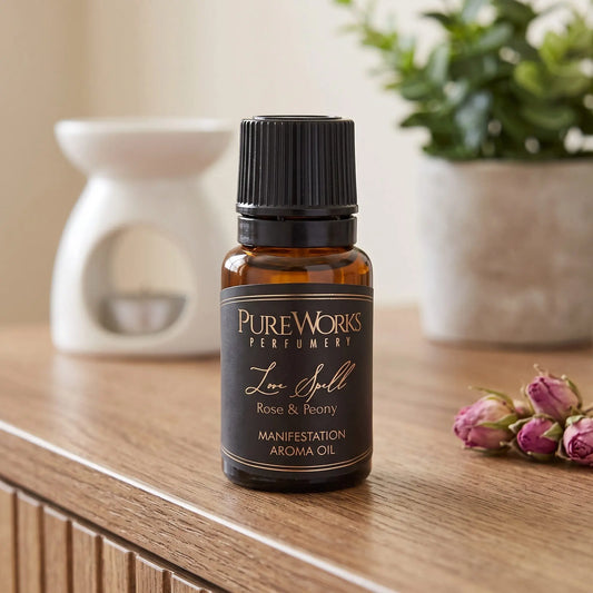 Aromaöl Love Spell (Rose & Pfingstrose): Fläschchen auf einem Holz-Sideboard im Wohnzimmer, im Hintergrund eine weiße Duftlampe, daneben getrocknete Rosenknospen