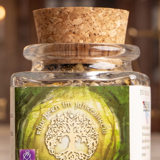 Wintersonnenwende – Jule, Jahreskreisfeste-Räuchermischung von Berk, 50 ml im Korkglas: Nahaufnahme von Korken, Glashals und Etikett mit dem Lebensbaum-Motiv vor der warmen, unscharfen Abendapotheke – Spirit of Gaia