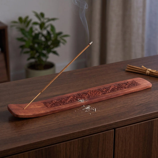 Räucherstäbchenhalter aus Akazienholz – mit OM-Symbol in Benutzung mit feinem Rauch auf einem dunklen Holz-Sideboard am Abend