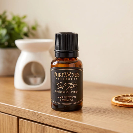 Aromaöl Good Fortune (Patchouli & Orange): Fläschchen auf einem Holz-Sideboard im Wohnzimmer, im Hintergrund eine weiße Duftlampe, daneben eine getrocknete Orangenscheibe