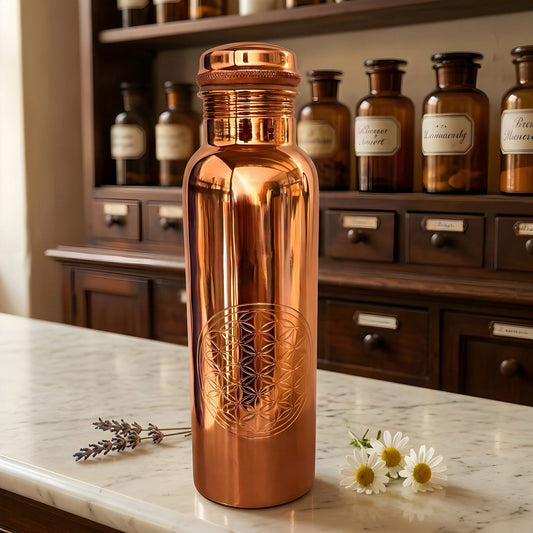 Polierte Kupfer-Trinkflasche mit gravierter Blume des Lebens auf Marmortheke vor Apothekerschrank – Spirit of Gaia
