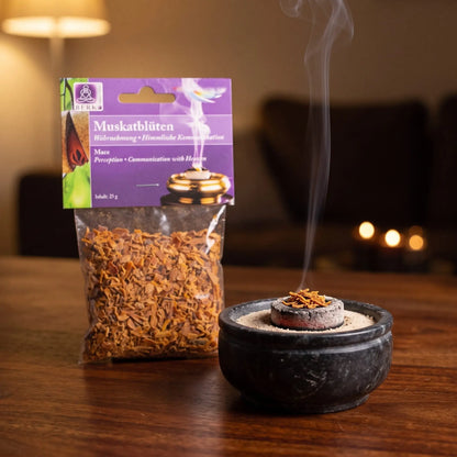 Muskatblüten (Macis), sortenreines Räucherwerk von Berk, 25 g: eine Prise Macis glimmt auf der Räucherkohle, dahinter die Tüte, feiner Rauch steigt auf einer dunklen Holzplatte am Abend auf – Spirit of Gaia