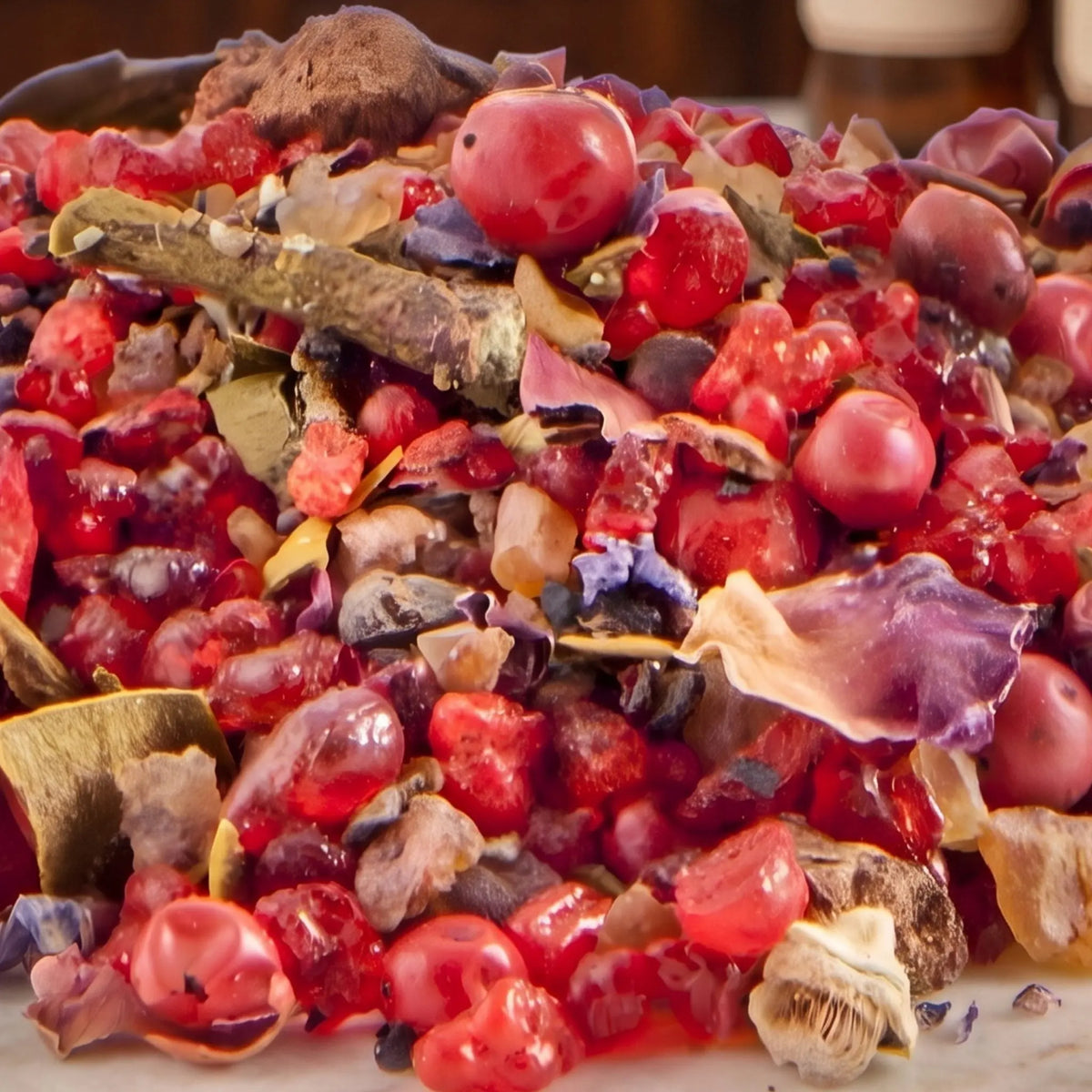 Pallas Athene, Räuchermischung der Reihe Aufgestiegene Meister von Berk, 60 ml im schwarzen Bügelglas: Nahaufnahme der Mischung mit rosa Pfefferbeeren und roten Beerenstücken auf Marmor vor der warmen, unscharfen Abendapotheke – Spirit of Gaia