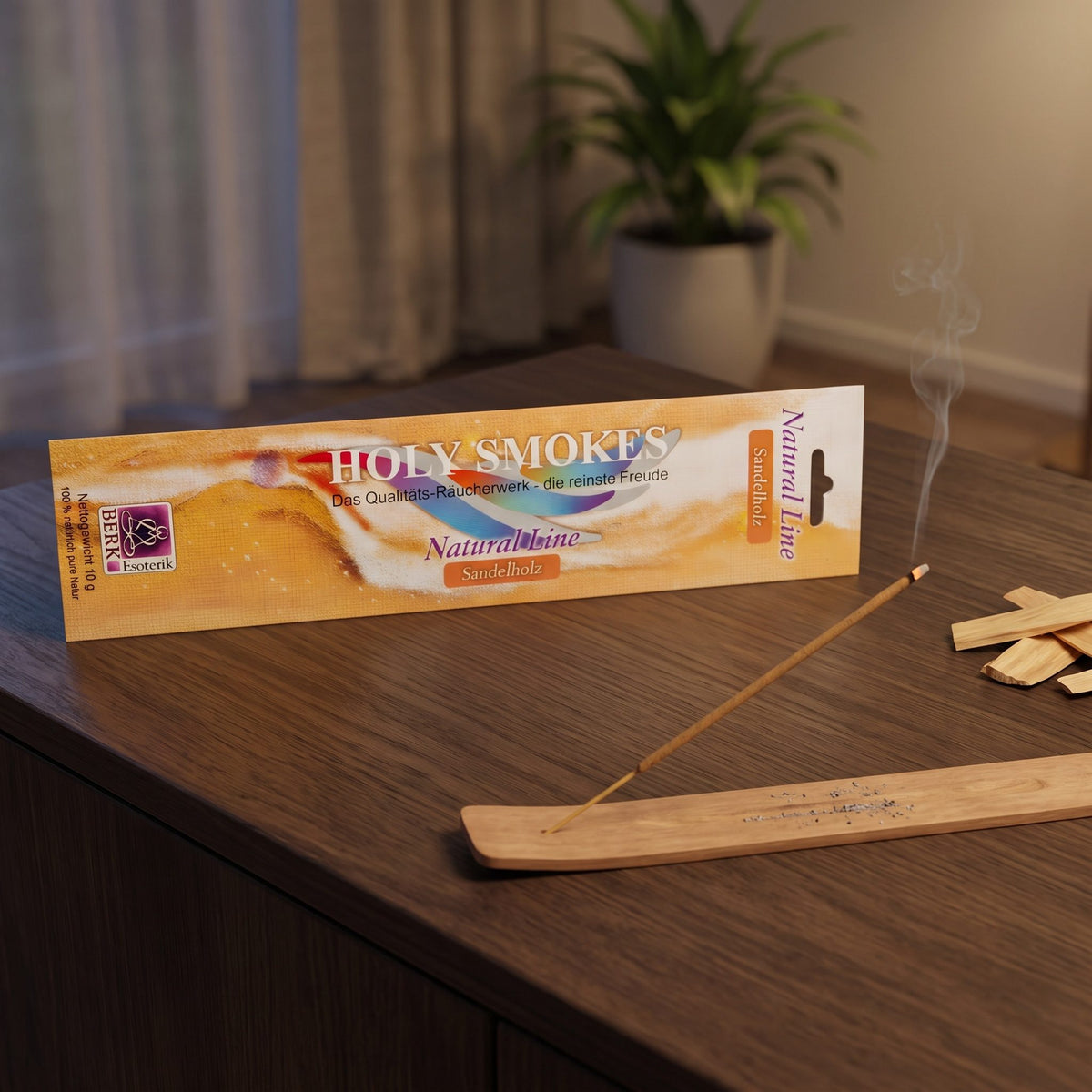 Sandelholz Räucherstäbchen Natural Line: glimmendes Stäbchen im Holzhalter auf einem dunklen Sideboard, dahinter die Packung, am Abend