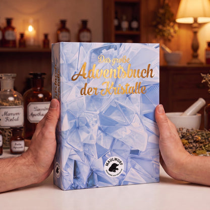 Zwei Hände halten den Kristall-Adventskalender im Buchformat, rund 24 mal 19 Zentimeter groß