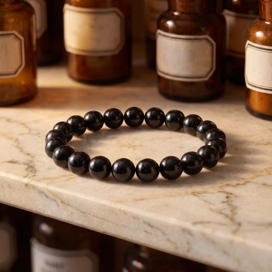 Schwarzer Turmalin Armband aus Schörl auf Marmorablage im Apothekerregal