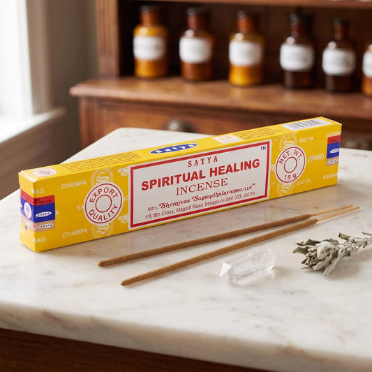 Satya Spiritual Healing Räucherstäbchen: 15-g-Packung auf einer Marmortheke vor einem Apothekerschrank, daneben zwei lose Räucherstäbchen – Spirit of Gaia