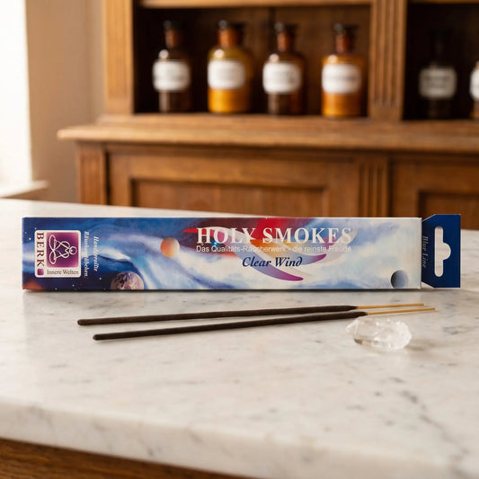Clear Wind Räucherstäbchen Holy Smokes Blue Line: Packung auf einer Marmortheke vor einem Apothekerschrank, davor zwei lose Räucherstäbchen und ein klarer Bergkristall – Spirit of Gaia