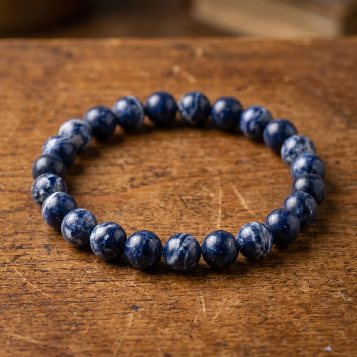 Makro der naturbelassenen, blau-weiß gemaserten Sodalith-Perlen des Edelstein-Kugelarmbands