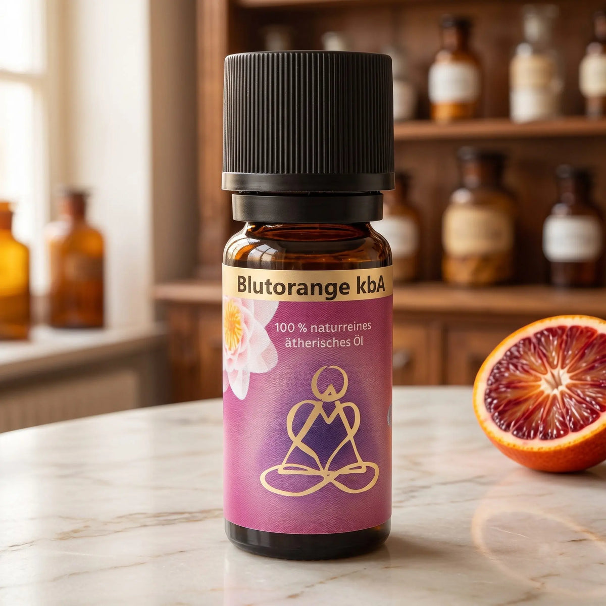 Ätherisches Öl Blutorange: Fläschchen aus Braunglas auf Marmortheke vor Apothekerschrank, daneben eine halbierte Blutorange – Spirit of Gaia