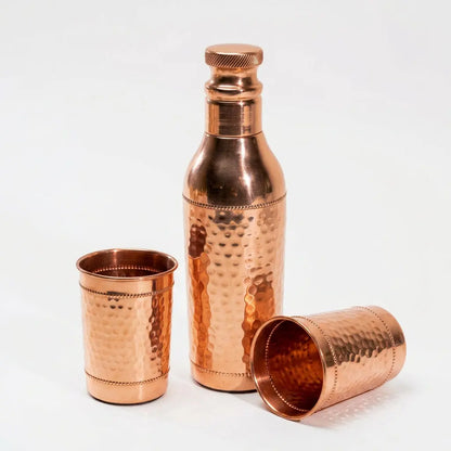 Gehämmertes Kupfer-Trinkset auf weißem Hintergrund, Flasche und zwei Becher