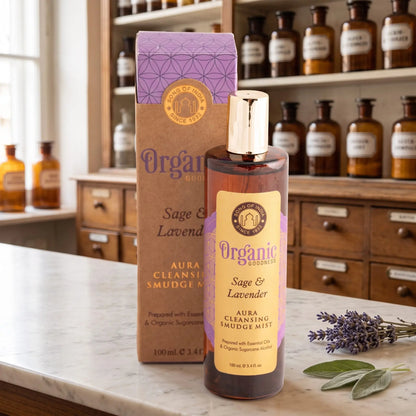 Aura Reinigungsspray Salbei und Lavendel von Organic Goodness: braune Sprühflasche mit goldener Kappe neben der Kraftpapier-Schachtel auf einer Marmortheke vor einem Apothekerschrank