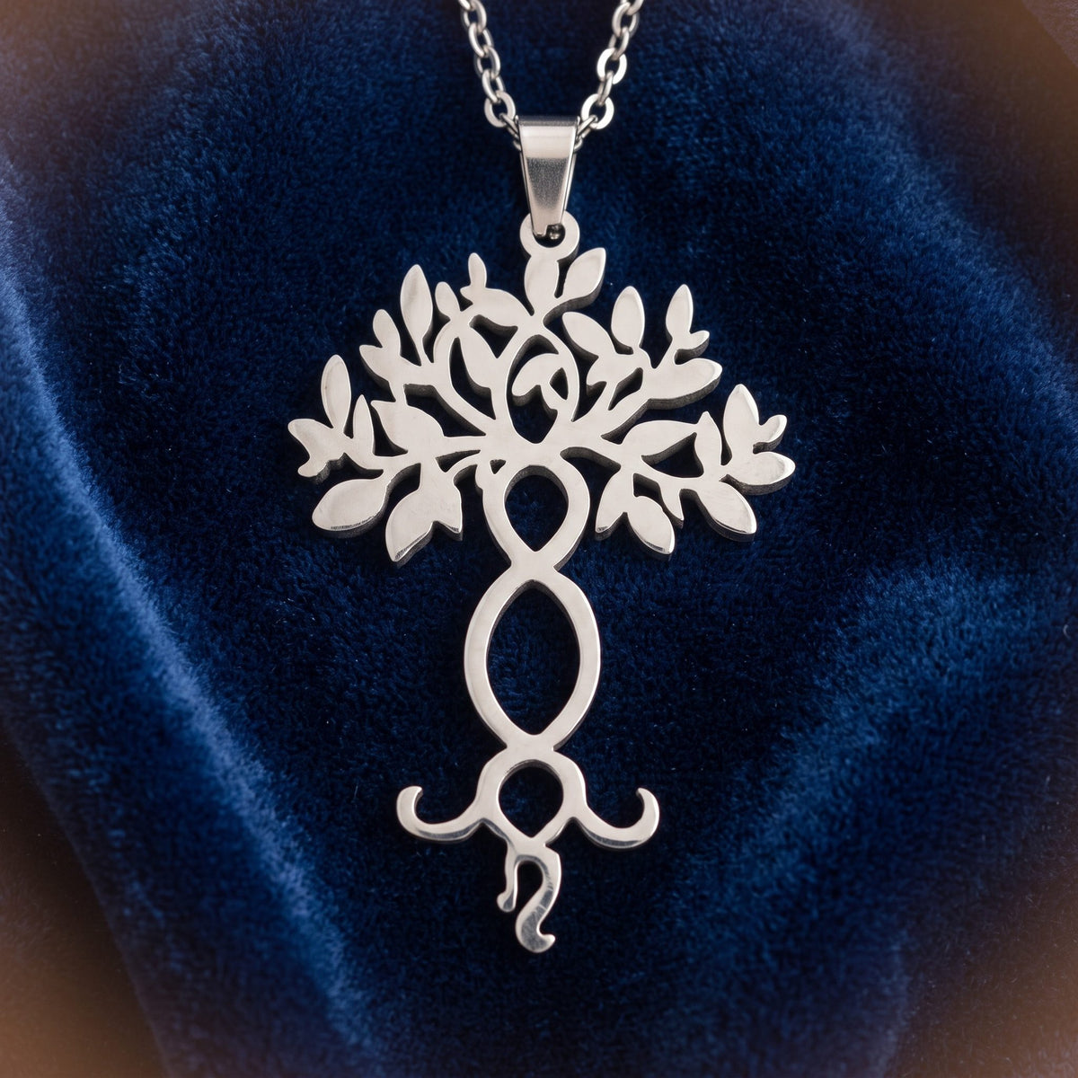 Filigraner Yggdrasil Anhänger aus Edelstahl an feiner Kette auf dunkelblauem Samt