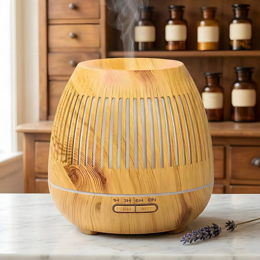 Aroma Diffuser Gaia in heller Holzoptik mit senkrechten Lichtschlitzen und feinem Nebel auf Marmortheke – Spirit of Gaia
