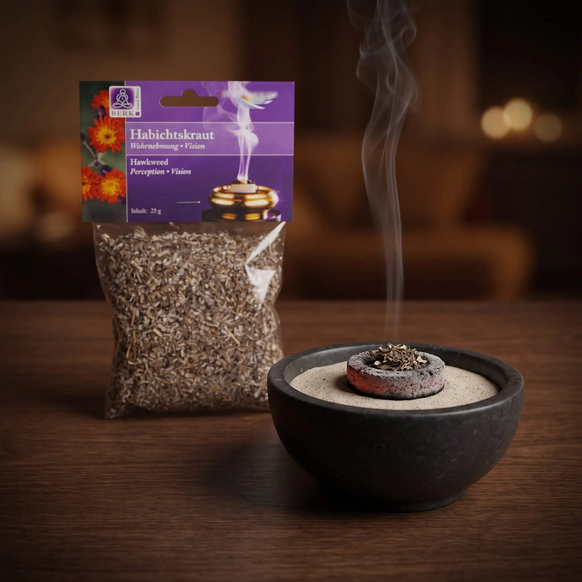 Habichtskraut, sortenreines Räucherwerk von Berk, 25 g: eine Prise Habichtskraut glimmt auf der Räucherkohle, dahinter die Tüte, feiner Rauch steigt auf einer dunklen Holzplatte am Abend auf – Spirit of Gaia