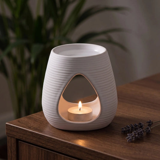 Aromalampe Pure White: mit brennendem Teelicht auf einem Holz-Sideboard im Wohnzimmer am Abend, daneben ein Lavendelzweig