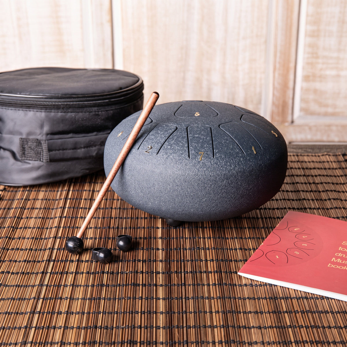 Die große dunkelblaue Steeldrum mit Klangstab, Fingerkuppen, Liederbuch und Tasche
