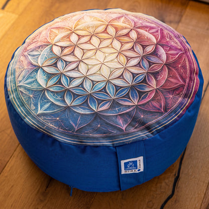 Nahaufnahme der Oberseite des Meditationskissens Blume des Lebens in Blau: Muster aus ineinandergreifenden Kreisen im Farbverlauf von Blaugrün über Cremegelb zu Rosa, Tragelasche mit Berk-Balance-Etikett