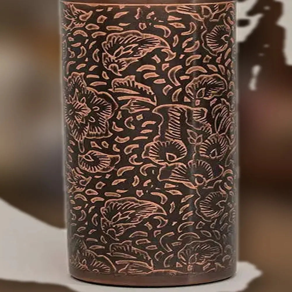 Makro des gravierten Blumenmusters auf der antiken Kupfer-Trinkflasche