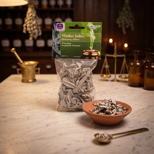 Weißer Salbei, lose in der Tüte, von Berk, 10 g: Packung auf der Marmortheke einer alten Apotheke am Abend, daneben eine Terracottaschale mit Blättern vom Weißen Salbei und ein Messinglöffel – Spirit of Gaia