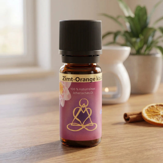 Ätherisches Öl Zimt-Orange: Fläschchen auf einem Holz-Sideboard im Wohnzimmer, im Hintergrund eine weiße Duftlampe, daneben eine Zimtstange und eine Orangenscheibe
