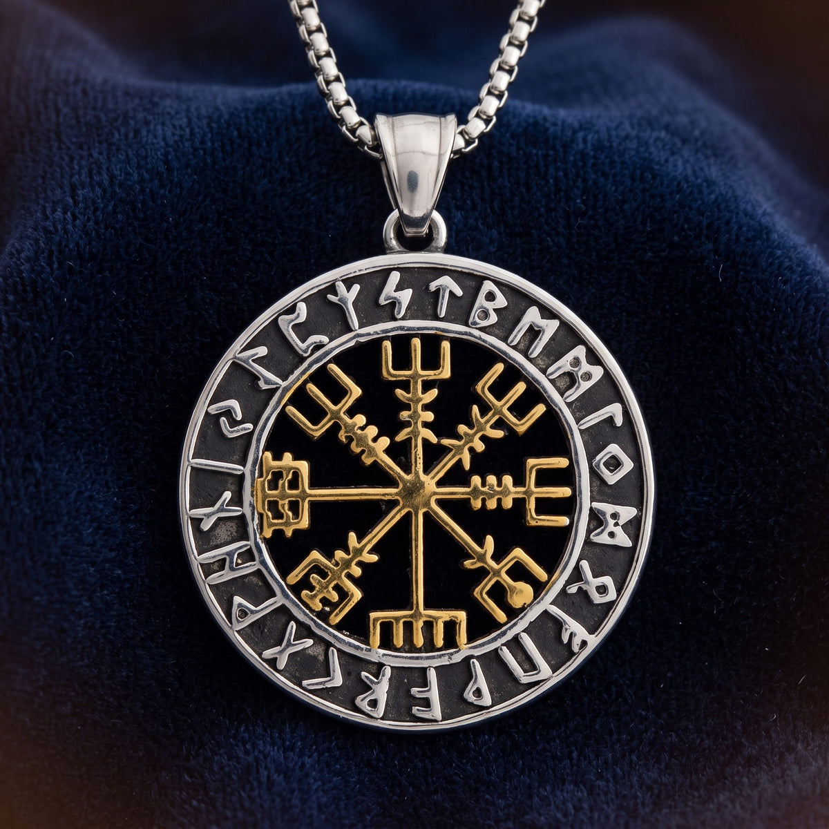 Vegvisir Anhänger aus Edelstahl mit goldfarbenem Zeichen und Runenring, an Kette auf dunkelblauem Samt
