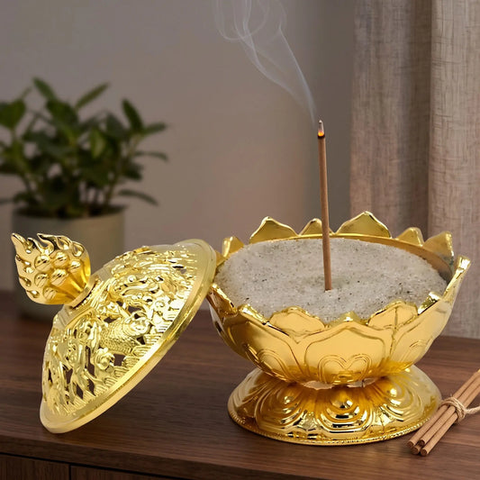 Räucherstäbchenhalter Lotus goldfarbig in Benutzung mit feinem Rauch auf einem dunklen Holz-Sideboard am Abend