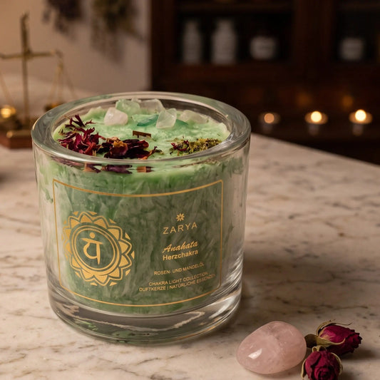 Chakra-Kerze Herzchakra Anahata mit Fluorit und Rosenquarz, Duft Rose und Mandel: Kerze im Glas auf der Marmortheke einer alten Apotheke am Abend, daneben ein Rosenquarz und getrocknete Rosenknospen – Spirit of Gaia