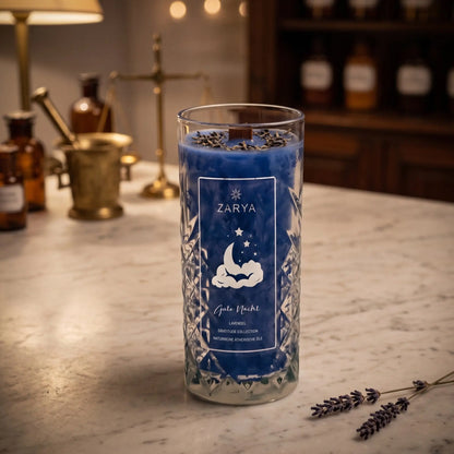 Zeremonie Kerze Gute Nacht im Kristallglas, Duft Lavendel: Kerze im Glas auf der Marmortheke einer alten Apotheke am Abend, daneben zwei Zweige getrockneter Lavendel – Spirit of Gaia