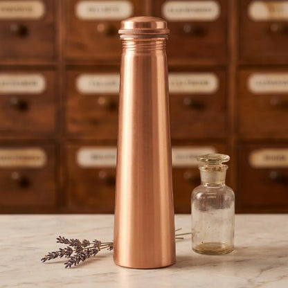 Matte Kupfer-Trinkflasche in Turmform auf Marmortheke vor Apothekerschrank – Spirit of Gaia