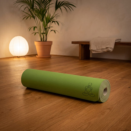 EcoBalance Yogamatte aus TPE, 182 × 61 cm, 6 mm, Baum des Lebens, hellgrün/grau: eingerollt auf dem Holzboden eines ruhigen Meditationsraums am Abend – Spirit of Gaia