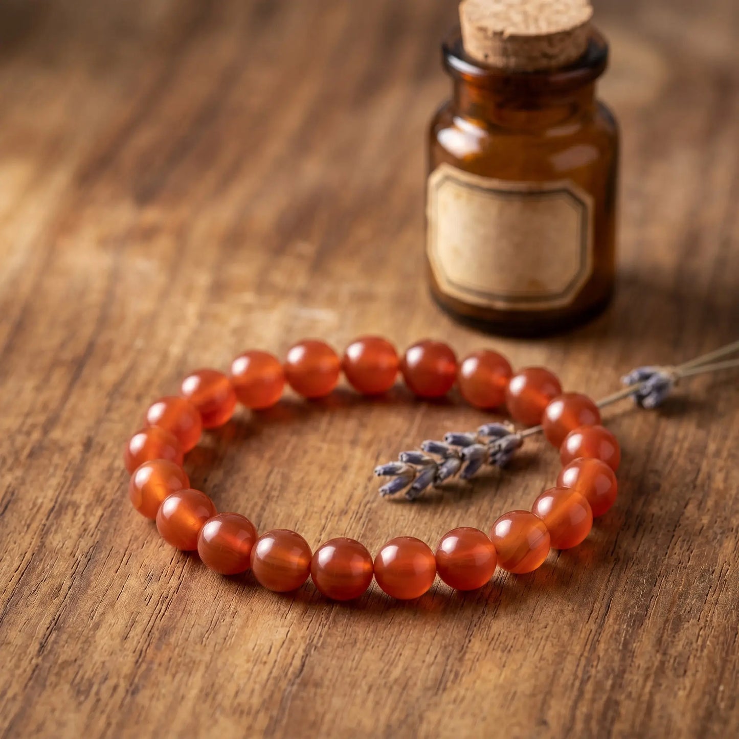 Karneol Kugelarmband auf warmem Holz mit getrocknetem Lavendel im Apotheker-Look