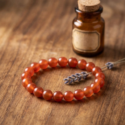 Karneol Kugelarmband auf warmem Holz mit getrocknetem Lavendel im Apotheker-Look