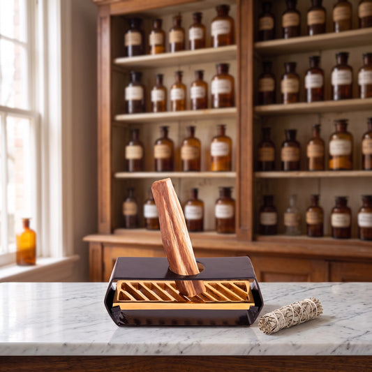 Halter für Palo Santo Sticks auf einer Marmortheke vor einem Apothekerschrank – Spirit of Gaia