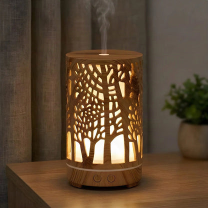 Aroma Diffuser Zen Forest leuchtet am Abend, das Licht fällt durch das Baum-Motiv, Nebel steigt auf