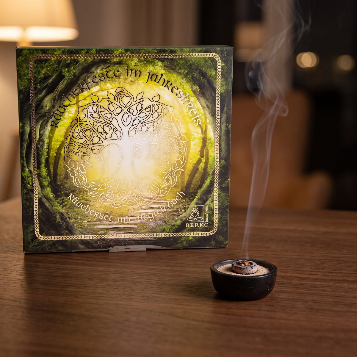 Räucherset Jahreskreisfeste von Berk: glimmende Räucherkohle in einer kleinen Specksteinschale vor der großen Geschenkbox, feiner Rauch steigt am Abend auf – Spirit of Gaia