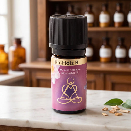 Ätherisches Öl Ho-Holz: Fläschchen aus Braunglas auf Marmortheke vor Apothekerschrank, daneben Holzspäne und Blätter – Spirit of Gaia