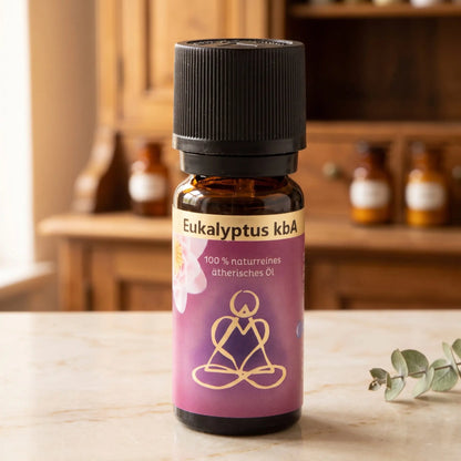 Ätherisches Öl Eukalyptus: Fläschchen aus Braunglas auf Marmortheke vor Apothekerschrank, daneben ein Eukalyptuszweig – Spirit of Gaia