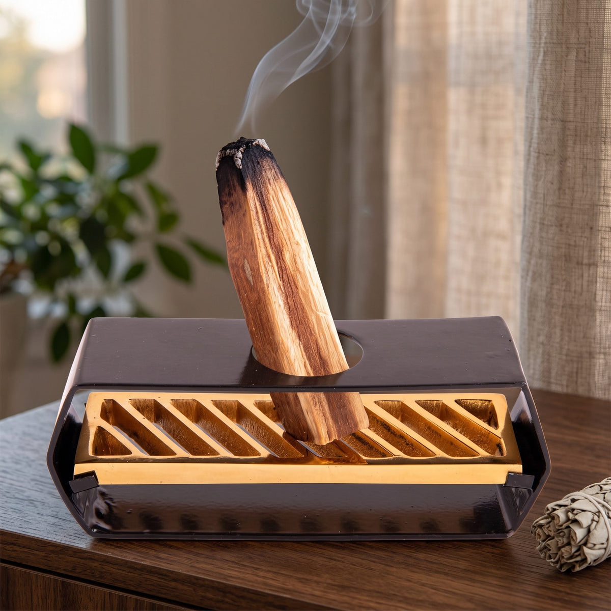 Halter für Palo Santo Sticks in Benutzung mit feinem Rauch auf einem dunklen Holz-Sideboard am Abend