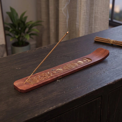 Räucherstäbchenhalter aus Akazienholz – mit Drachen in Benutzung mit feinem Rauch auf einem dunklen Holz-Sideboard am Abend