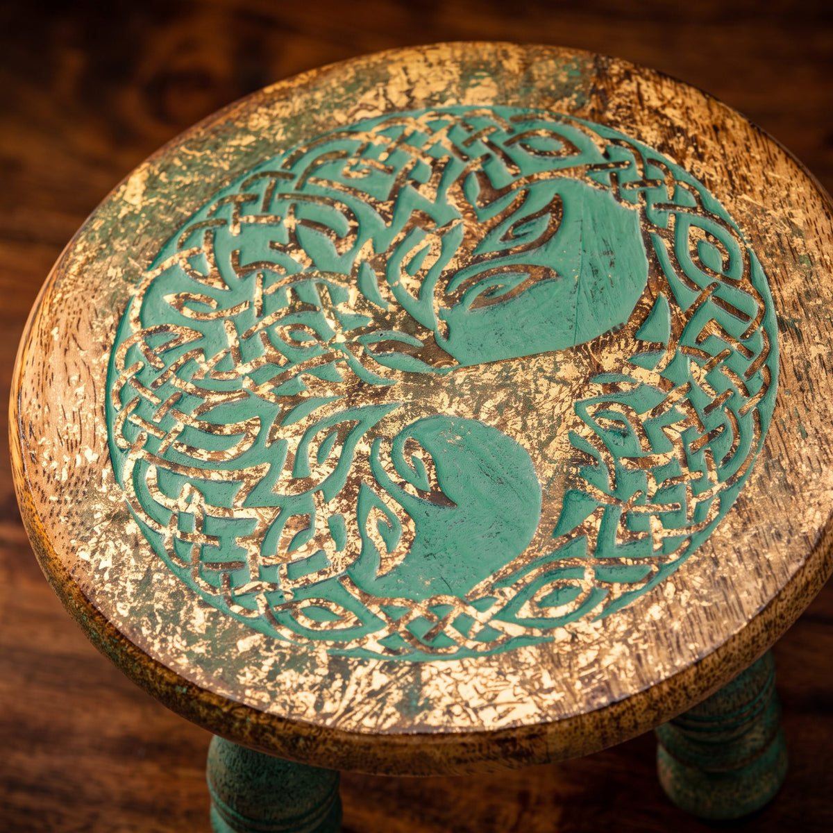 Nahaufnahme des geschnitzten Baums des Lebens auf dem Altartischchen: türkisgrüne Linien, Gold im Holz