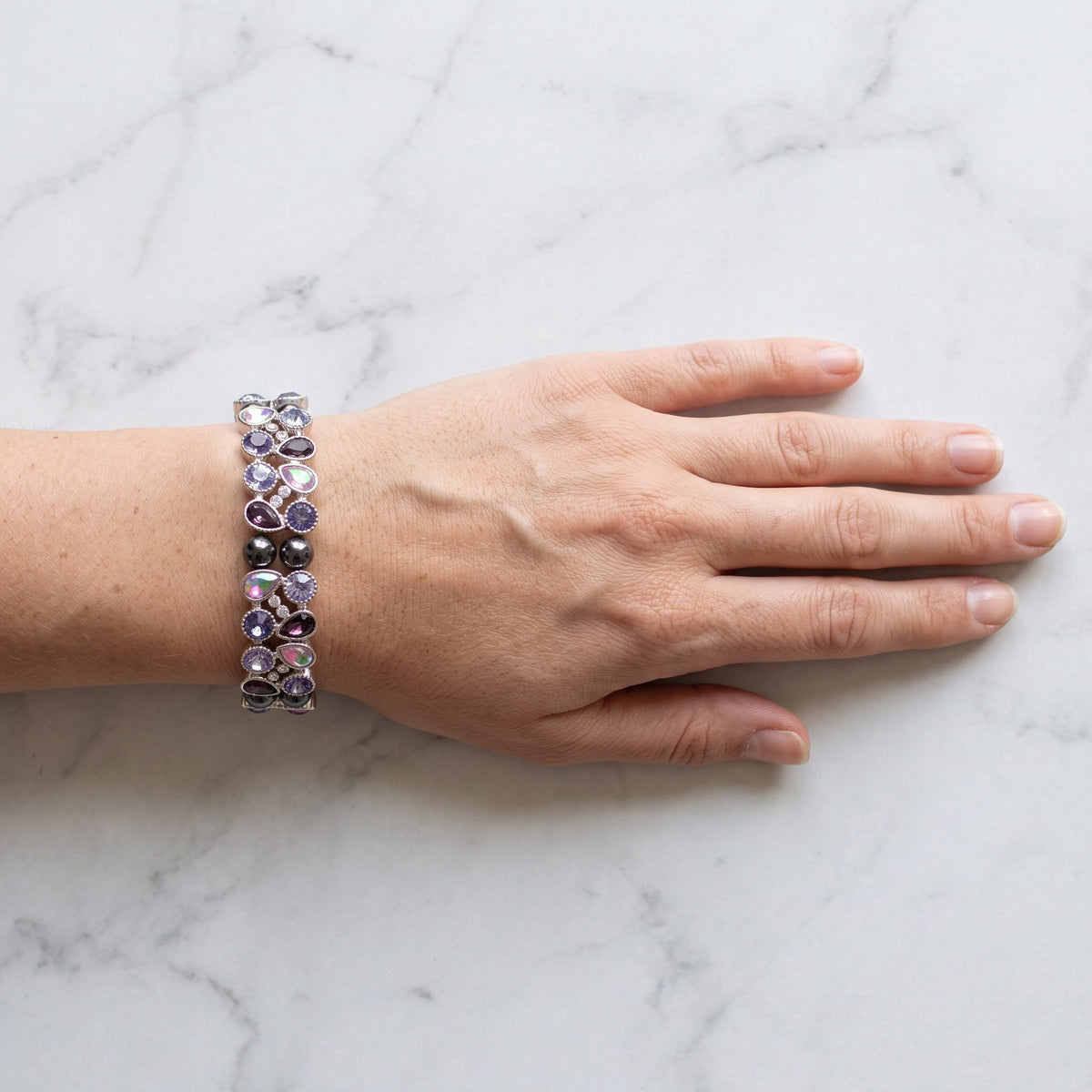 Das Kristallarmband Lavendelglitzer am Handgelenk, Blick von oben auf den Handrücken